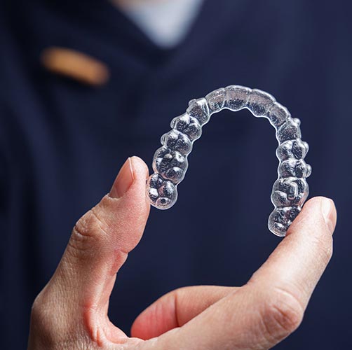 dentist holding aligners