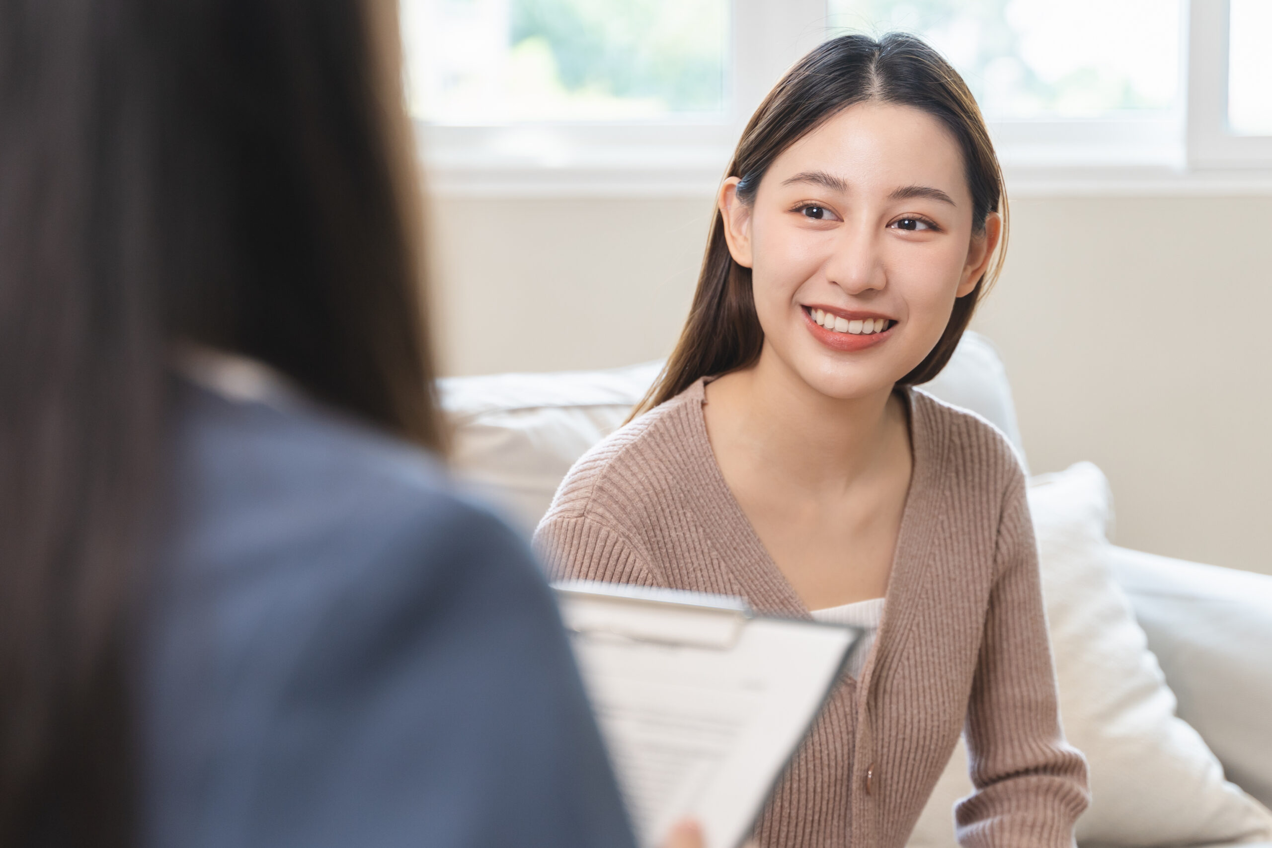 Young woman in a mental therapy session talking with a psychologist in the office.