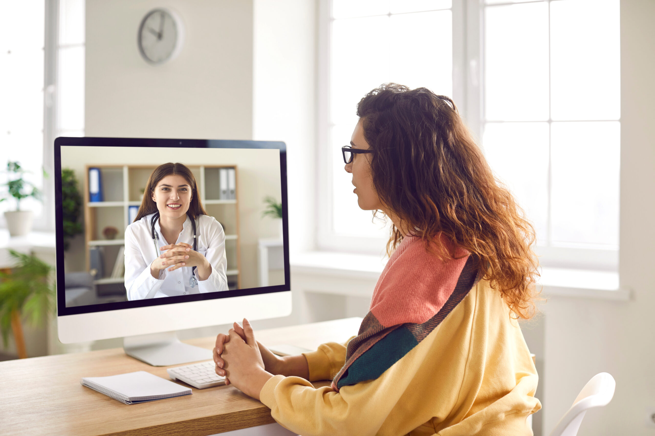 Sick woman listening recommendations having online video call with a doctor at home.
